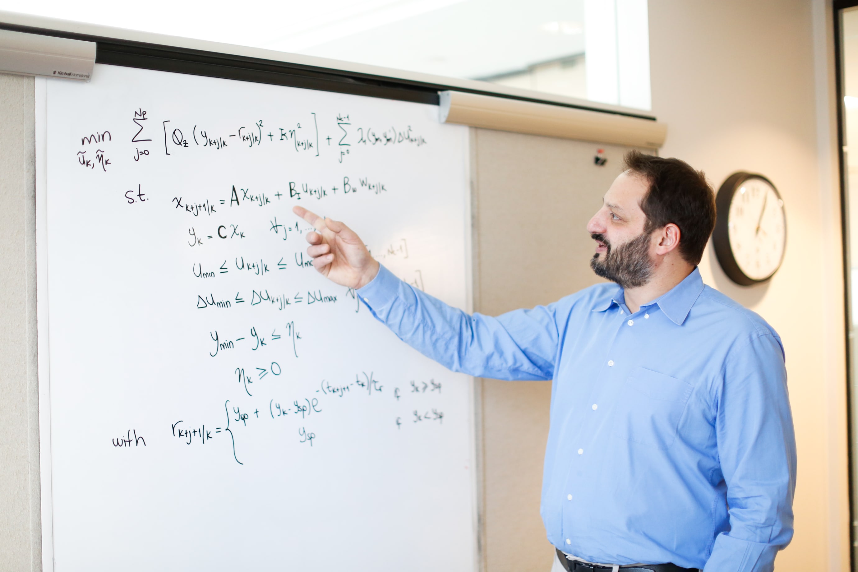 Marc Breton pointing at whiteboard